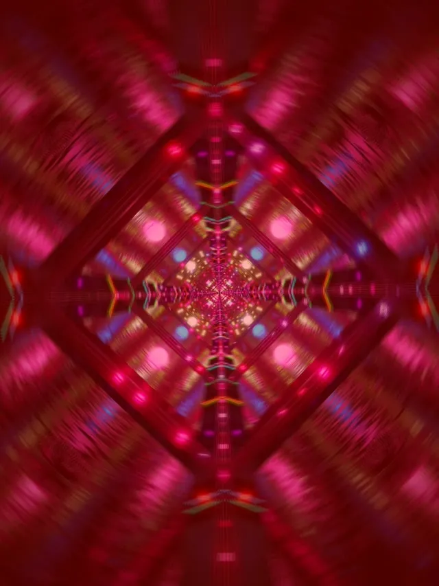 Symetryczny czerwony i różowy tunel neonowy ze świecącym wzorem kaleidoskopu diamentowego, rozmycie ruchu tworzy hipnotyczną głębię, żywa pętla VJ